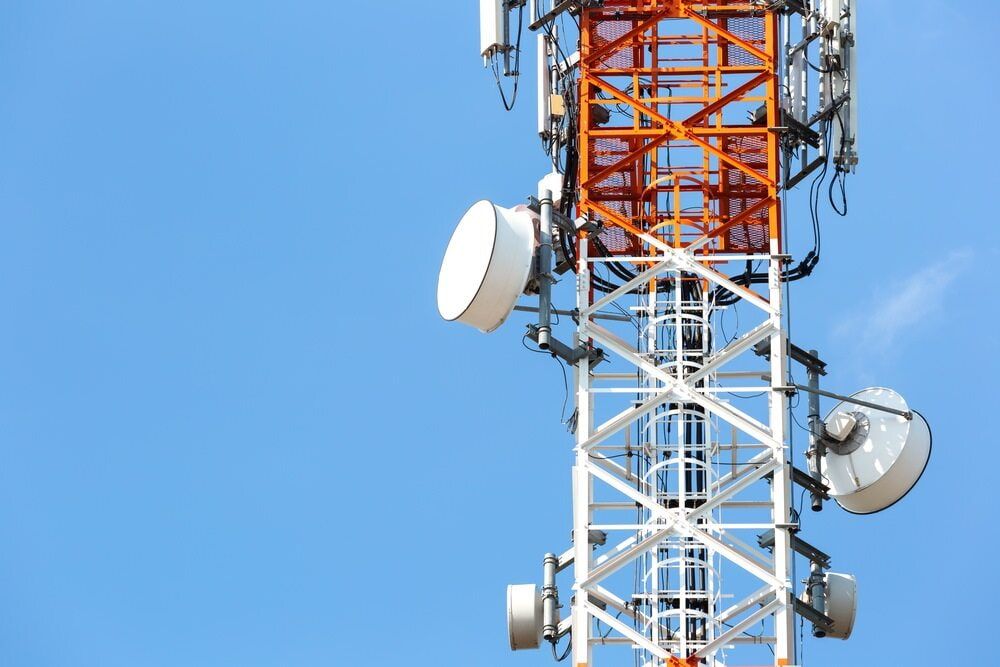 A Red and White Telephone Tower With Antennas Against a Blue Sky — Jendata In Garbutt, QLD