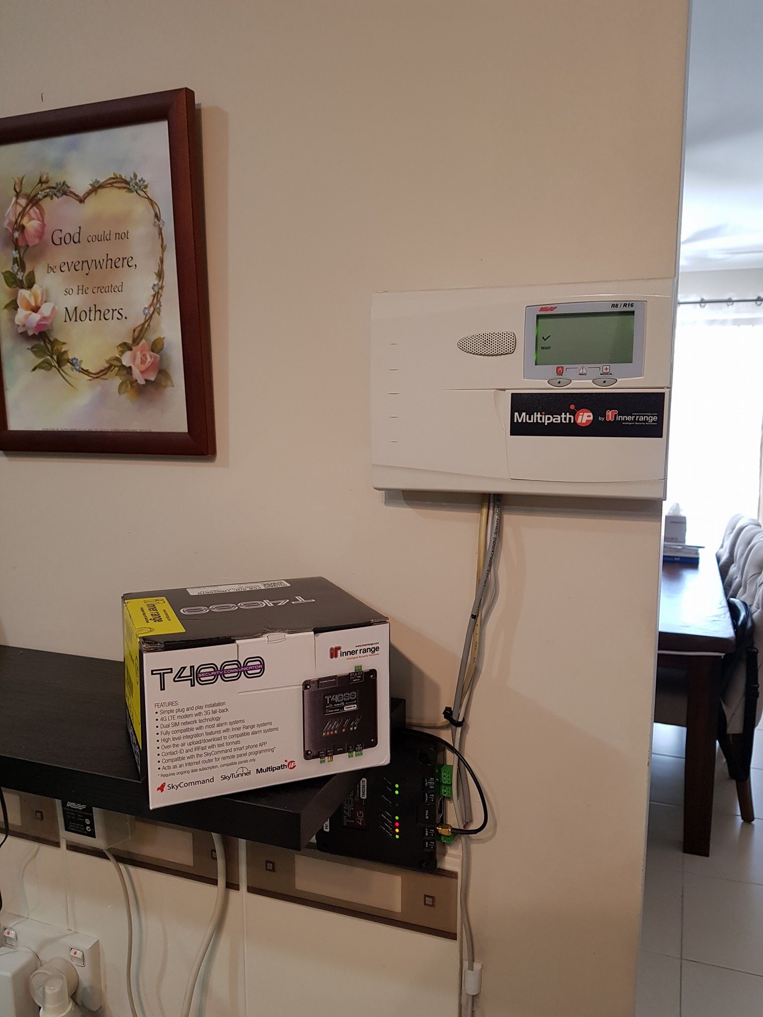 Security system control panel and new box on a wall near a dining area and a framed artwork — Jendata In Garbutt, QLD