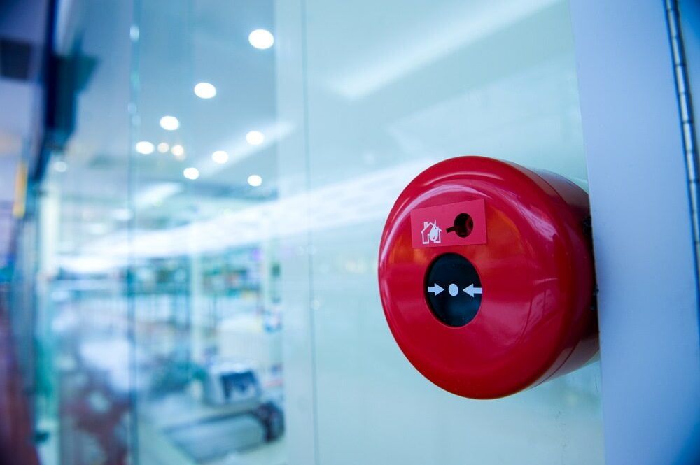 A Red Fire Alarm is Sitting on a Wall in a Building — Jendata In Garbutt, QLD