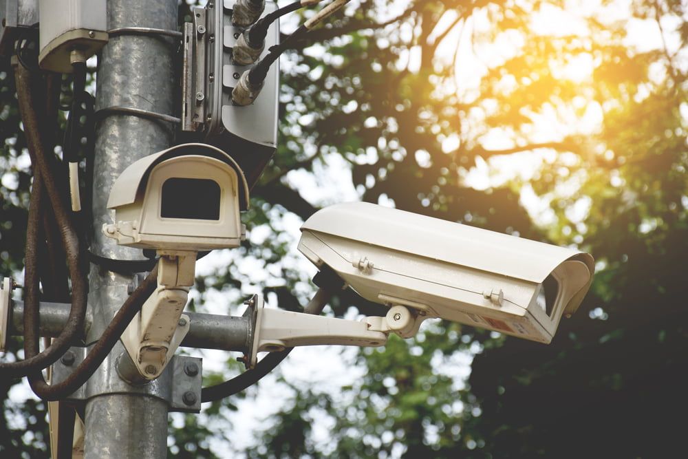 A Couple of Security Cameras Sitting on Top of a Pole — Jendata In Garbutt, QLD