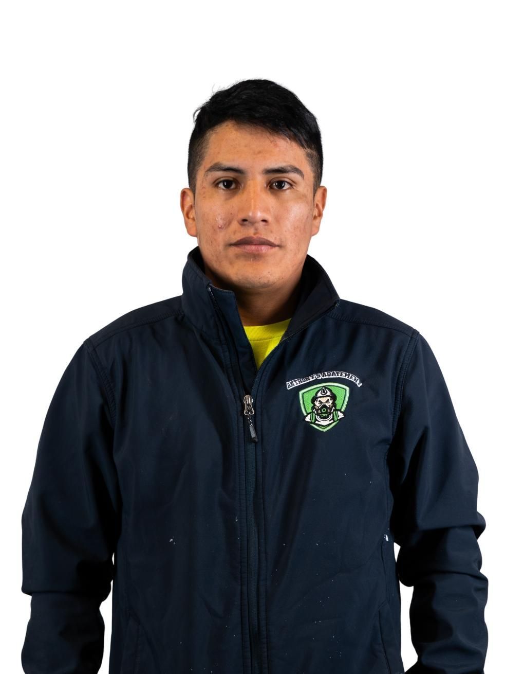 Person in a navy jacket with a logo, standing against a white background.