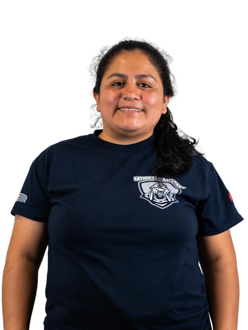 Smiling person in a navy T-shirt with a wolf logo, standing against a white background.