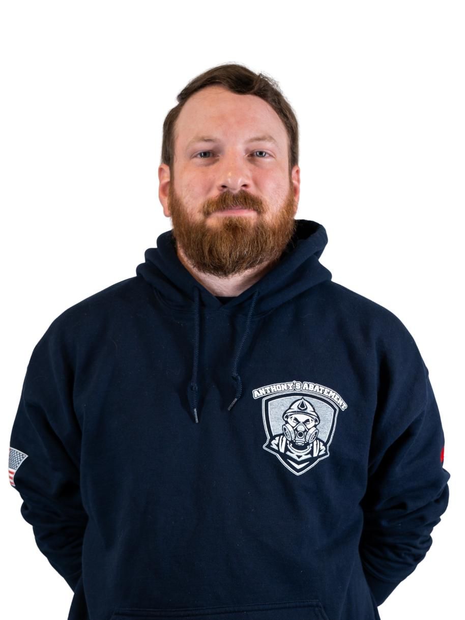 Person in a navy hoodie with a white emblem, standing against a plain white background.
