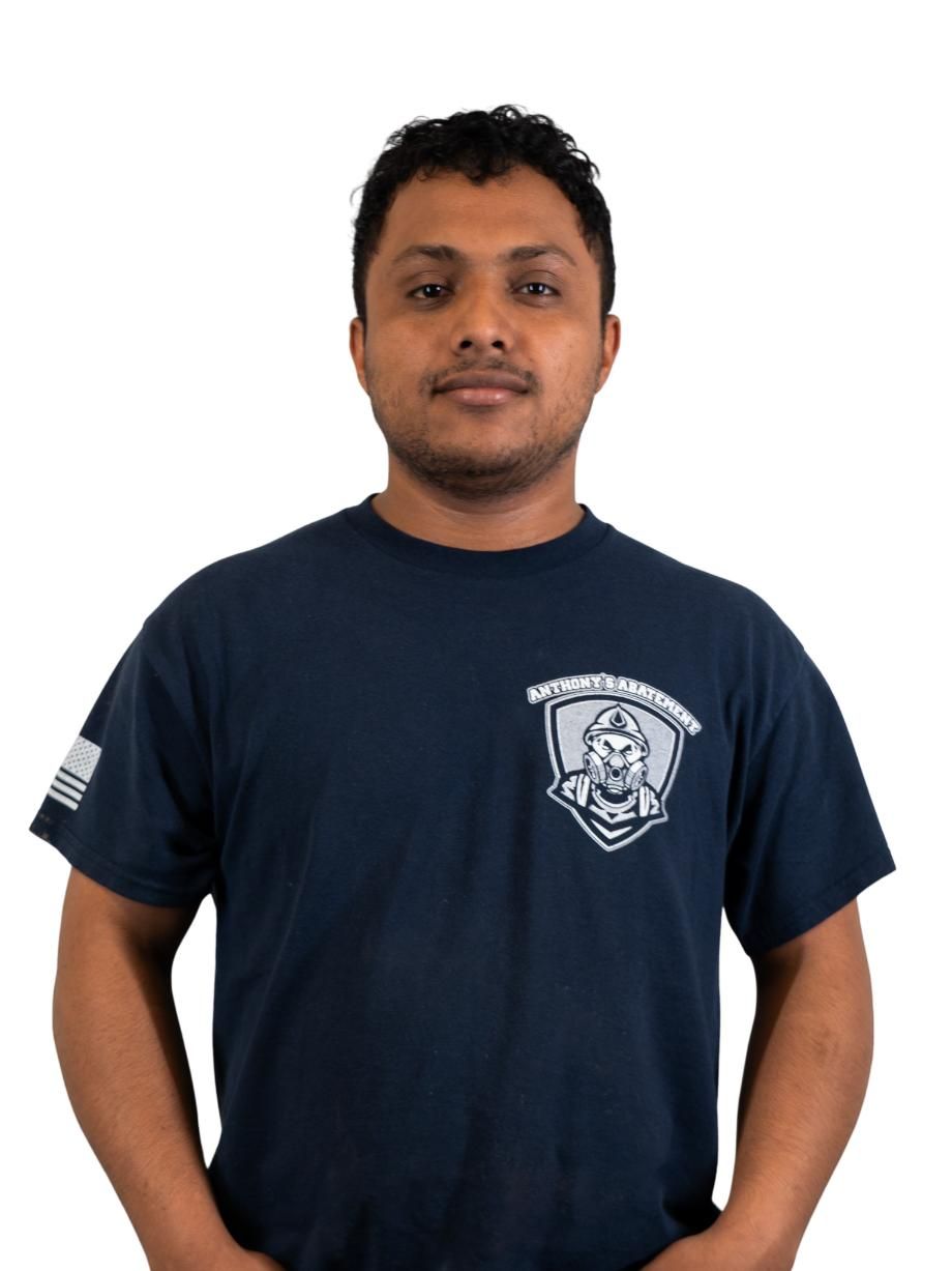 Person wearing a navy T-shirt with a small logo, standing against a plain white background.