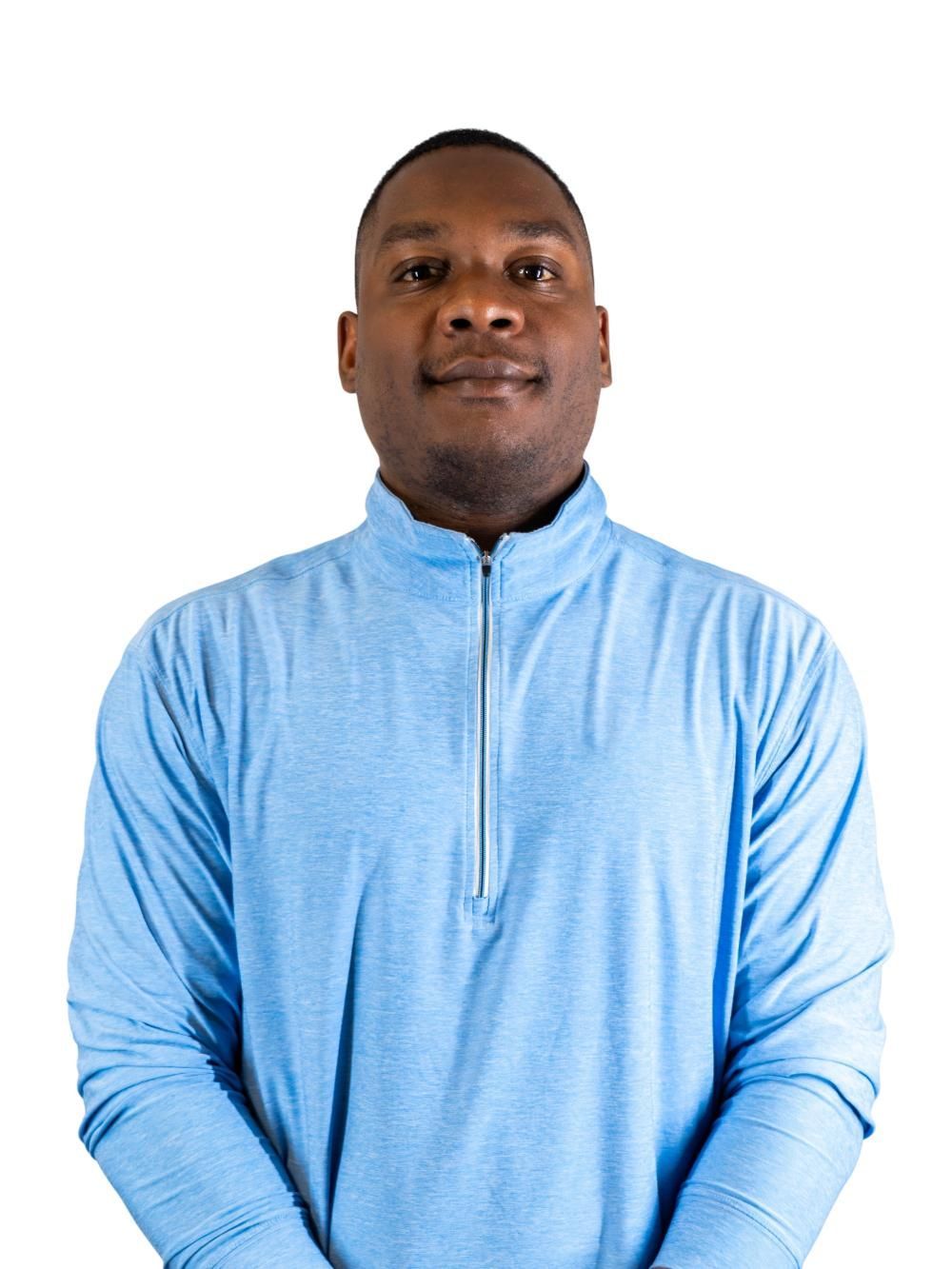 Person in a light blue quarter-zip top against a white background, facing forward with a neutral expression.