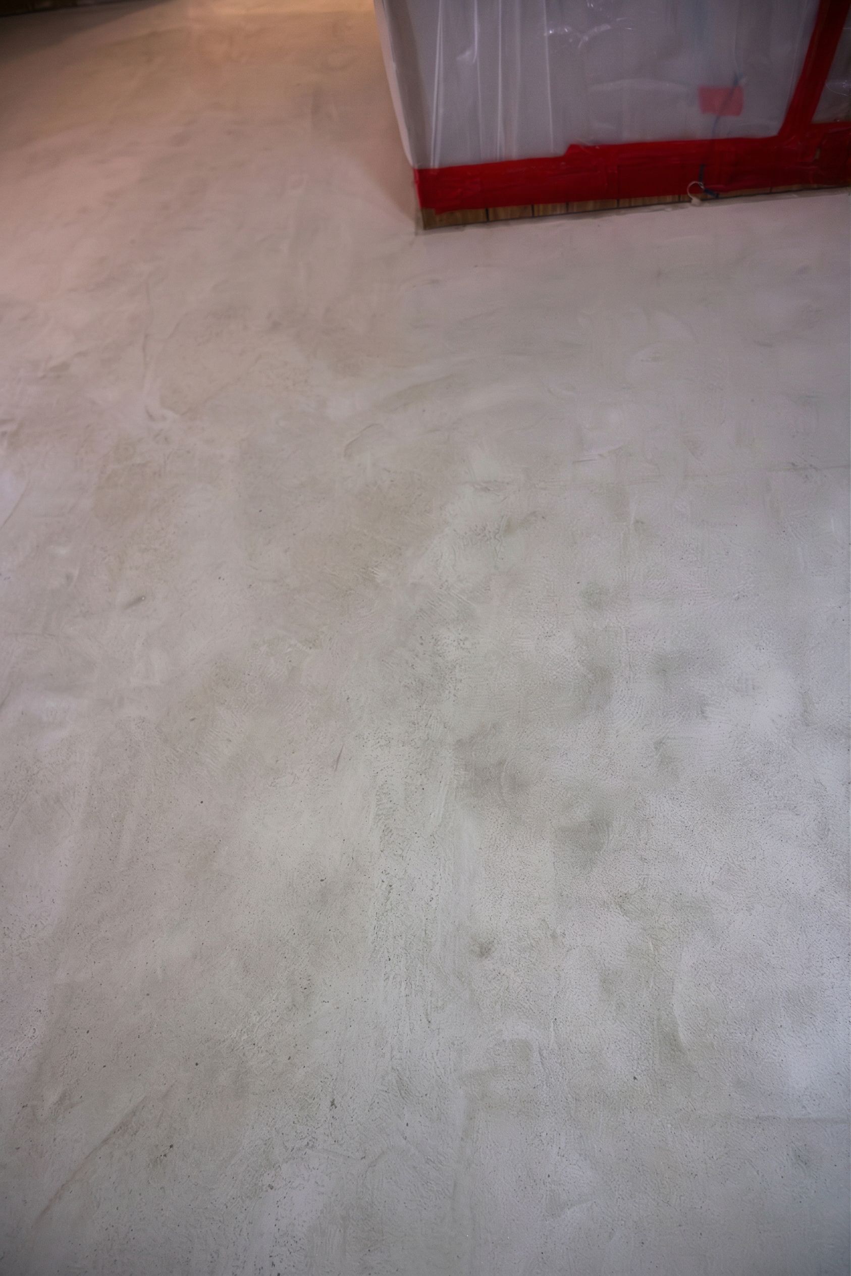 Light beige carpet with part of a red-framed crate at the top edge