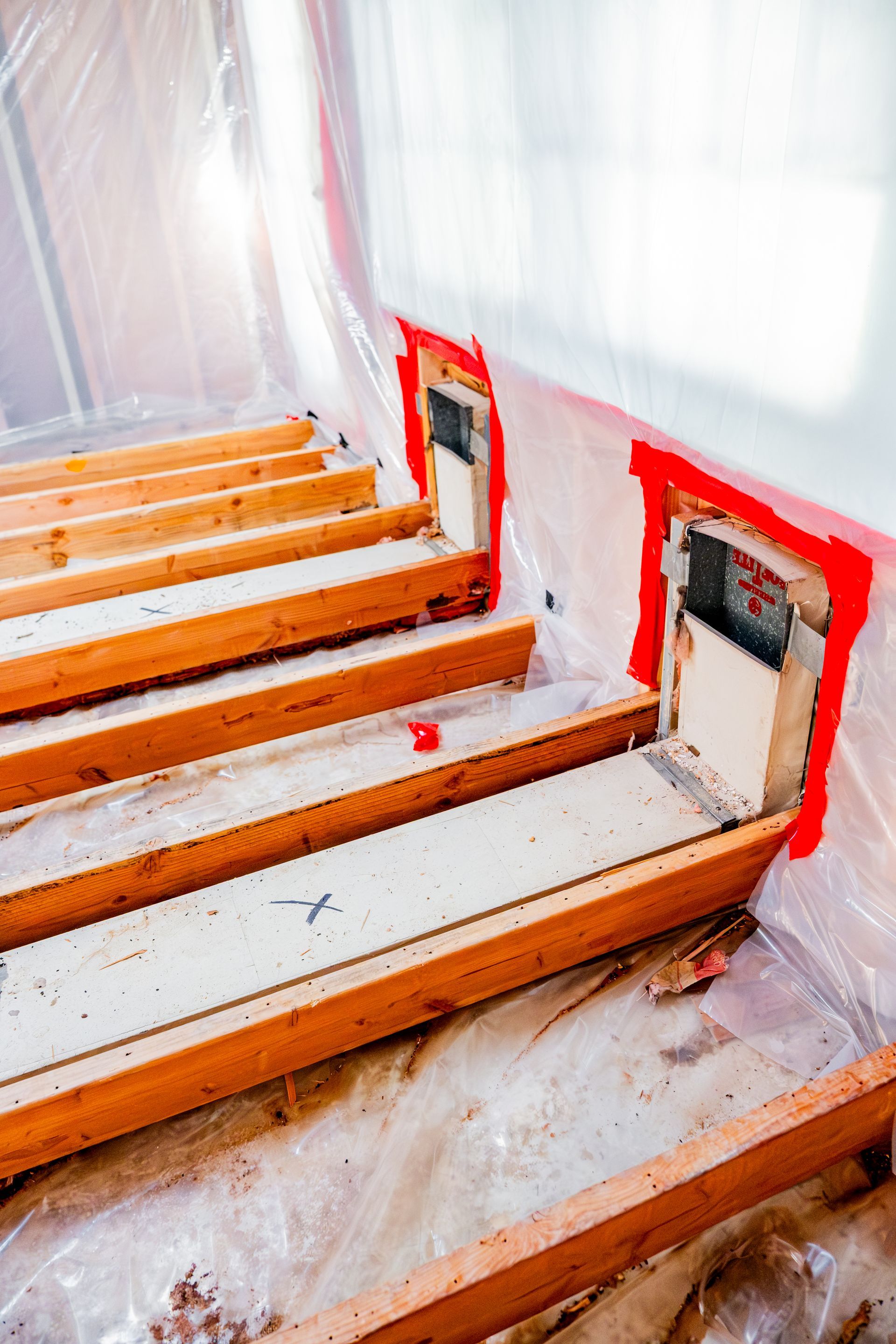 Wooden stairs under construction with red spray paint markings around step openings