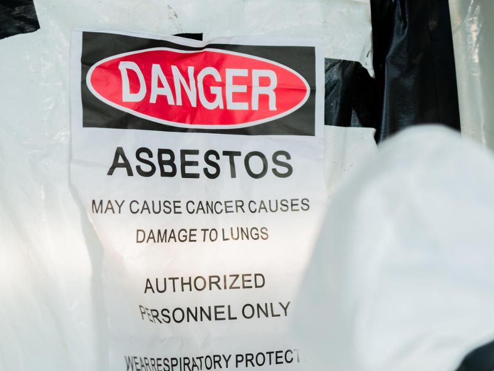 A danger sign that says asbestos may cause cancer causes damage to lungs