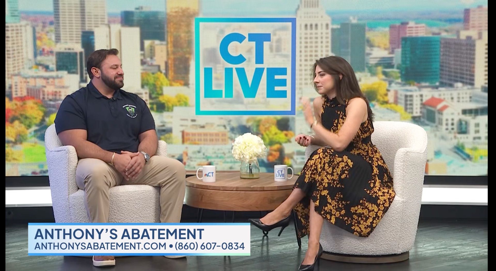 Man and woman on a TV set with the logo 