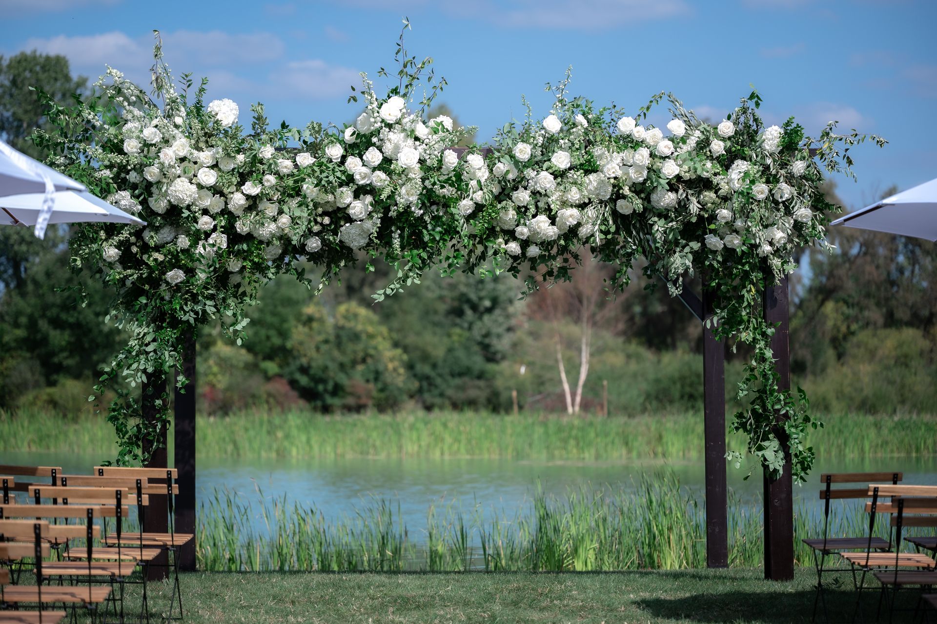 A wedding ceremony is taking place in front of a lake.