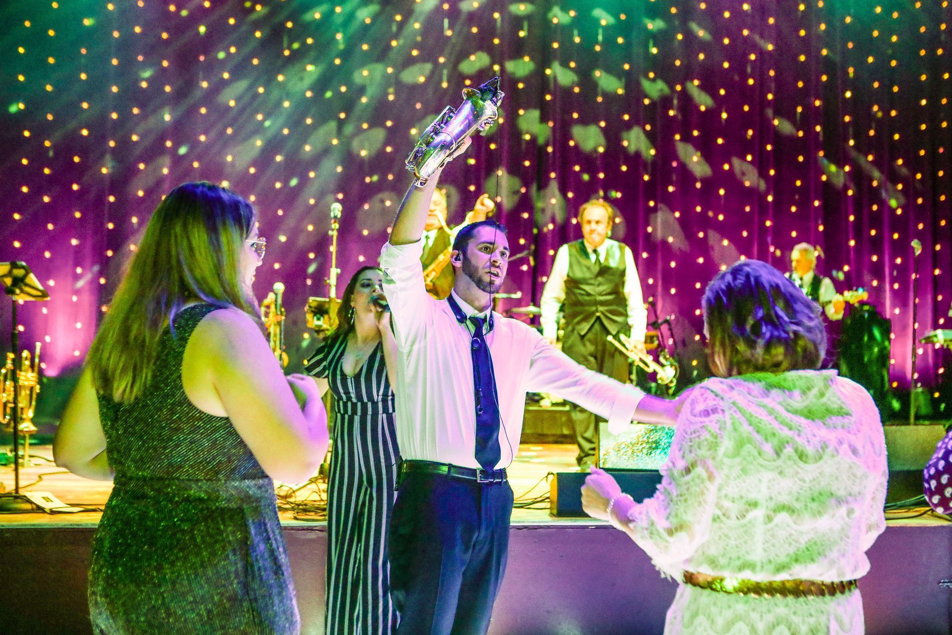 a group of people are dancing on a stage at a party .