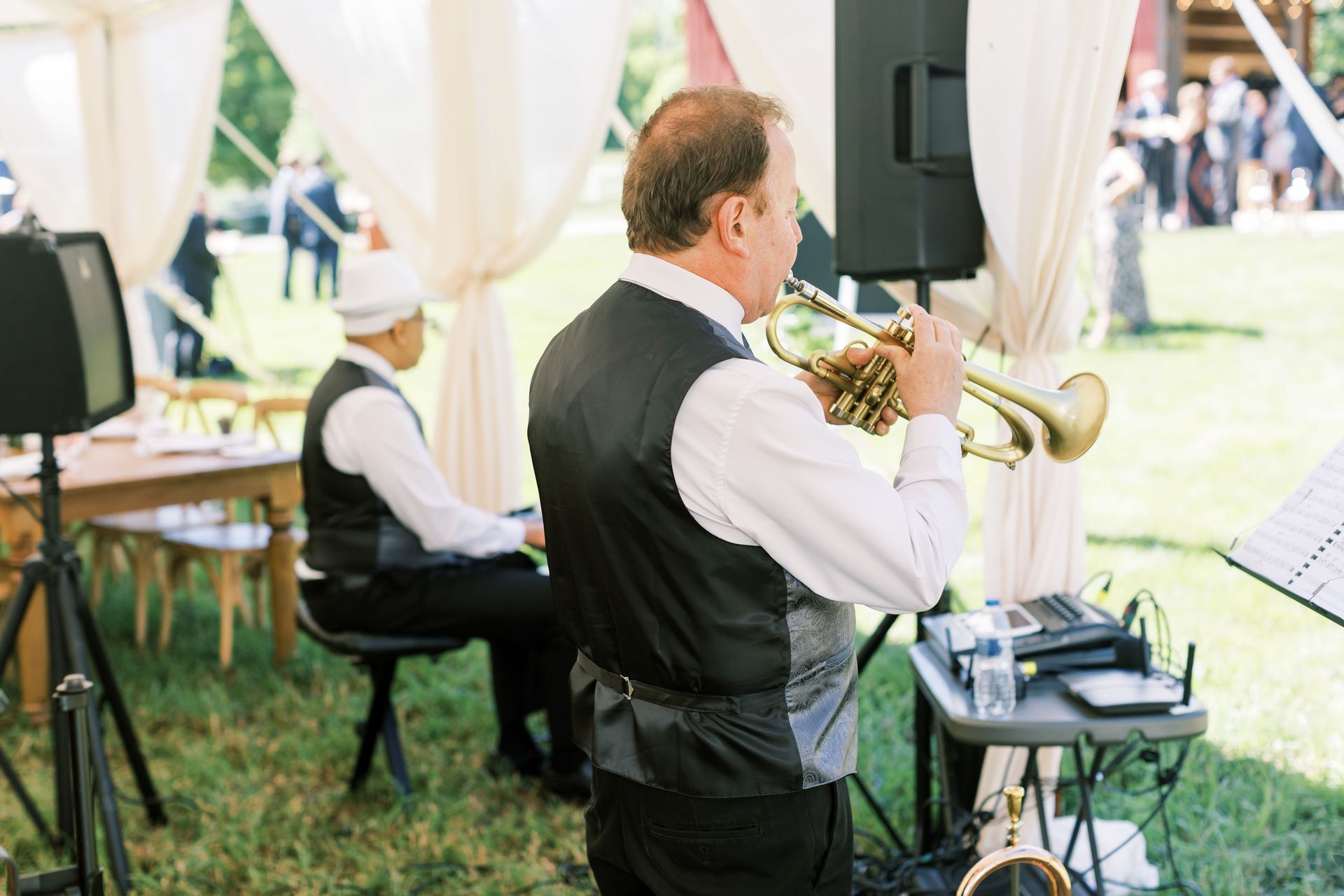 Band member from Mainstreet Soul playing a  trumpet while another member plays a piano