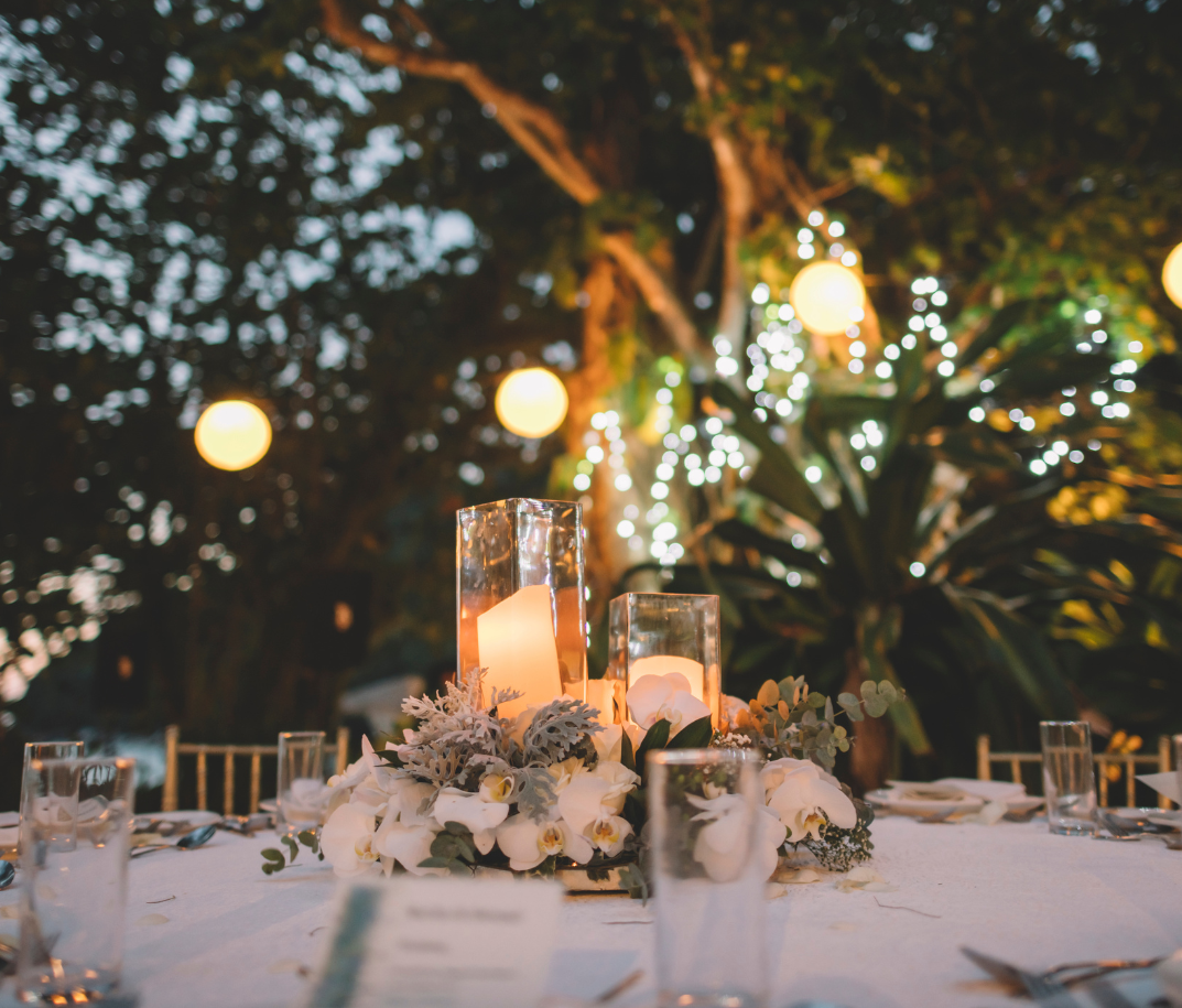 a table with a vase of flowers and a candle on it