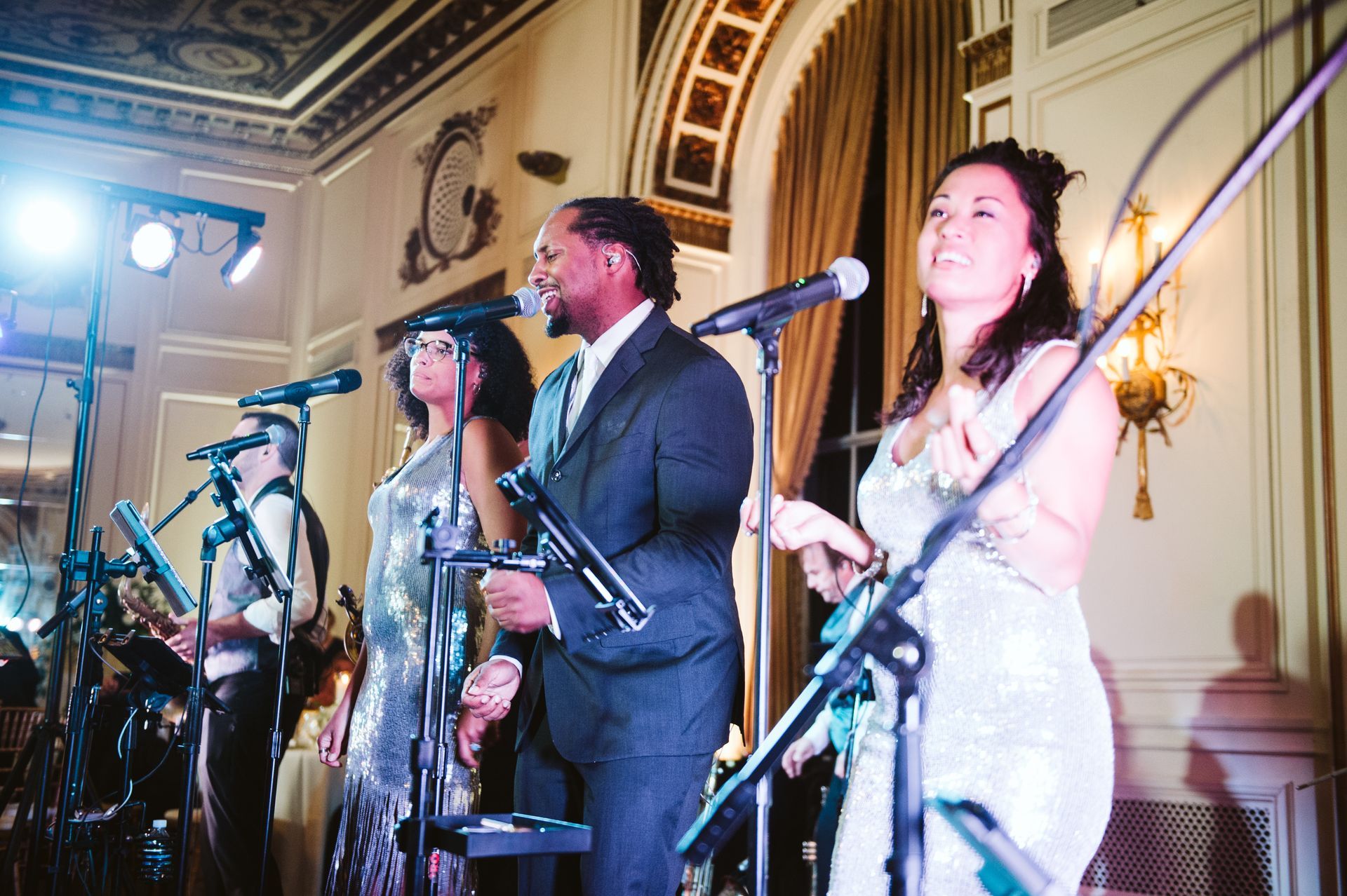 Mainstreet Soul singing into microphones on a stage.