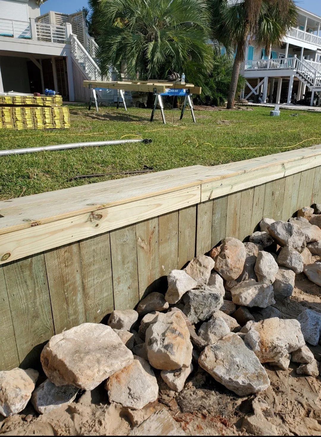 A pile of rocks is sitting next to a wooden fence.