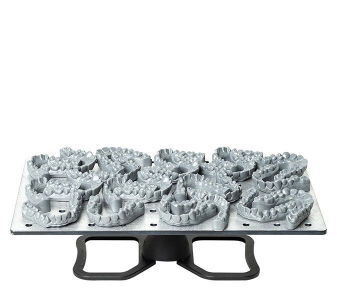 Een dienblad met 3D-geprinte tanden staat op een tafel.