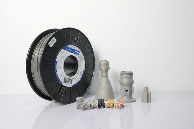 Een spoel met 3D-printfilament wordt omgeven door verschillende objecten.