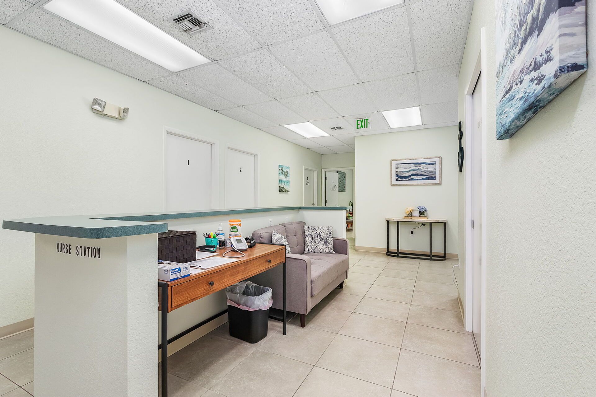 Bright hospital waiting room with beige chairs, white walls, and a small table