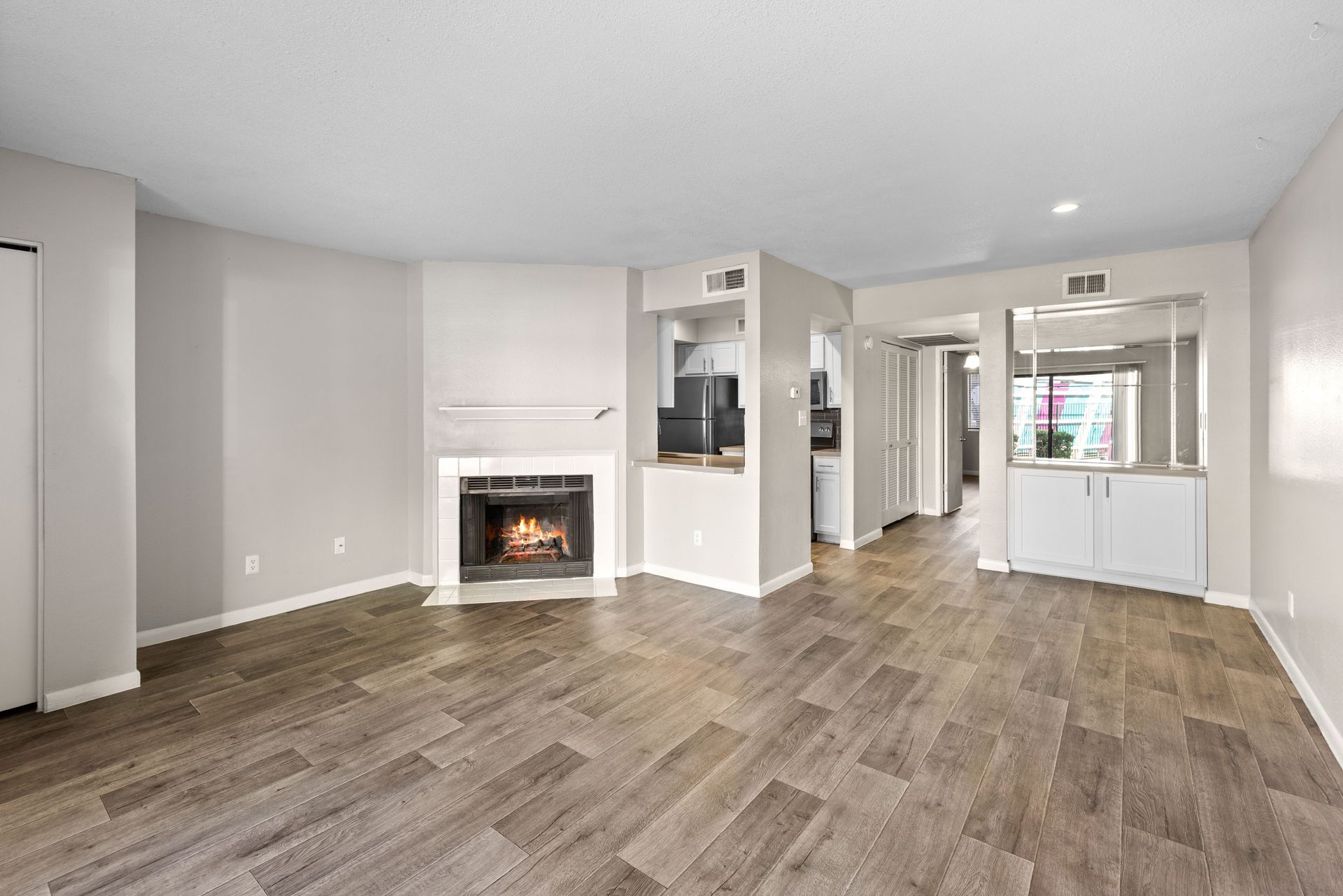 Living room with fireplace, wood flooring, and neutral walls.