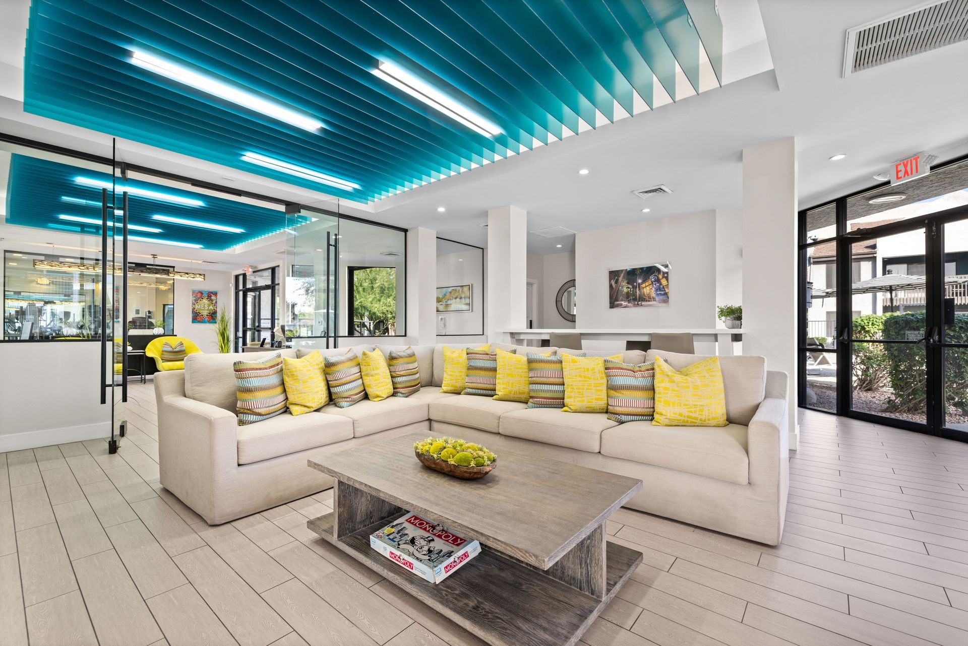 Modern living room with a large sectional sofa, wooden coffee table, and teal ceiling.