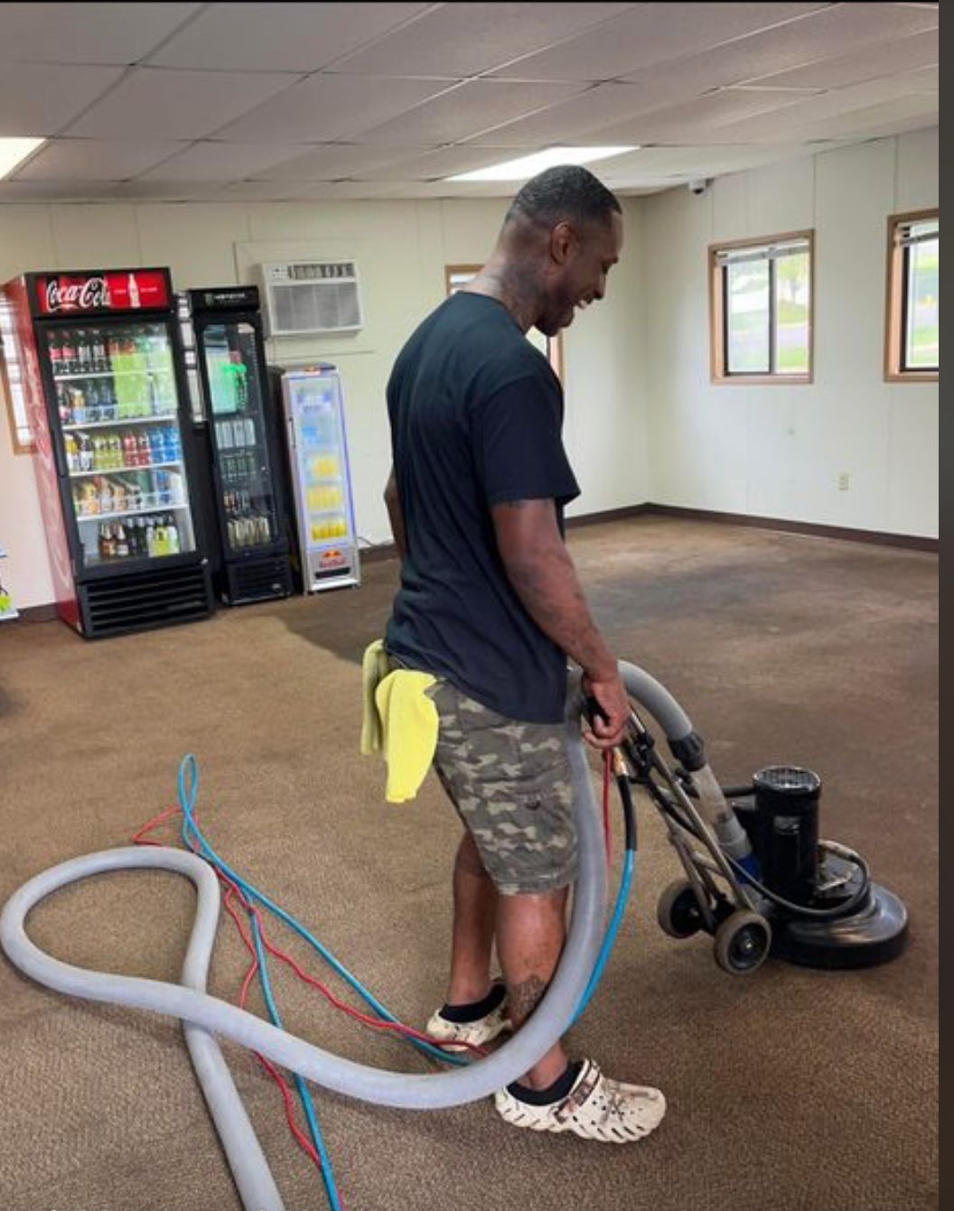 A person is cleaning a carpet with a vacuum cleaner.