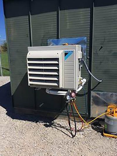 A large air conditioner is attached to the side of a building.