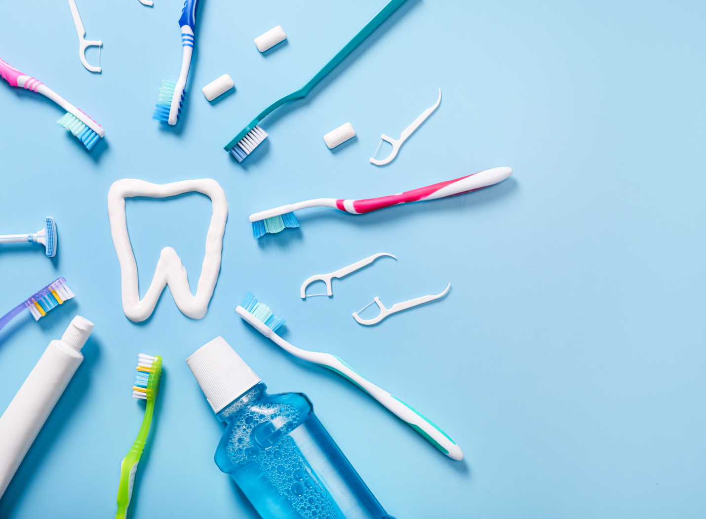 Dental hygiene tools arranged around a tooth shape on a light blue background