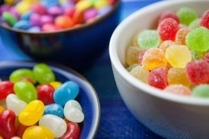 Three bowls filled with colorful assorted candies, including jelly beans, gumdrops, and chocolate-coated candies. Three bowls filled with colorful assorted candies, including jelly beans, gumdrops, and chocolate-coated candies.