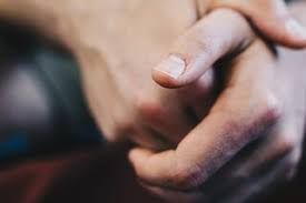 Two hands clasped together in a close-up, suggesting comfort or support.