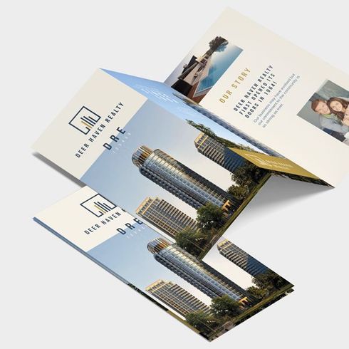 Three folded real estate brochure mockups with building photos and blue-white design on a white background