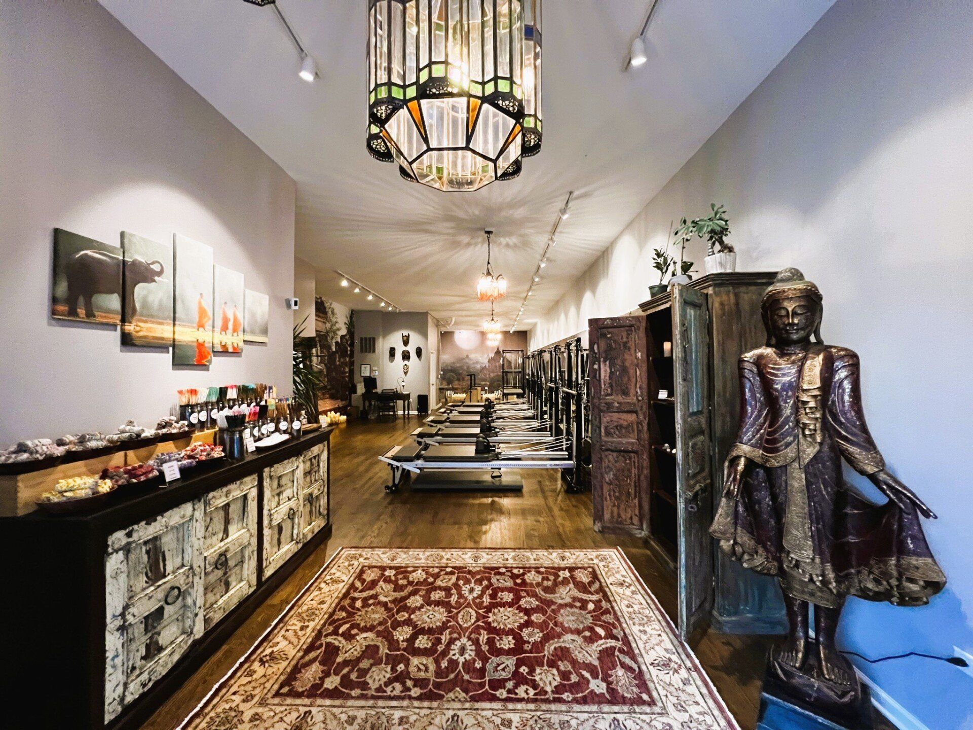 full image of the inside of the Metaphysical Pilates studio including shopping area, reformers, and a female Buddha statue