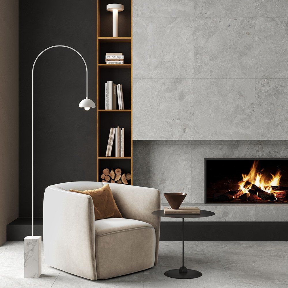 Modern living room with wood flooring, white chairs, a small black table, and a fireplace. Modern living room with wood flooring, white chairs, a small black table, and a fireplace.
