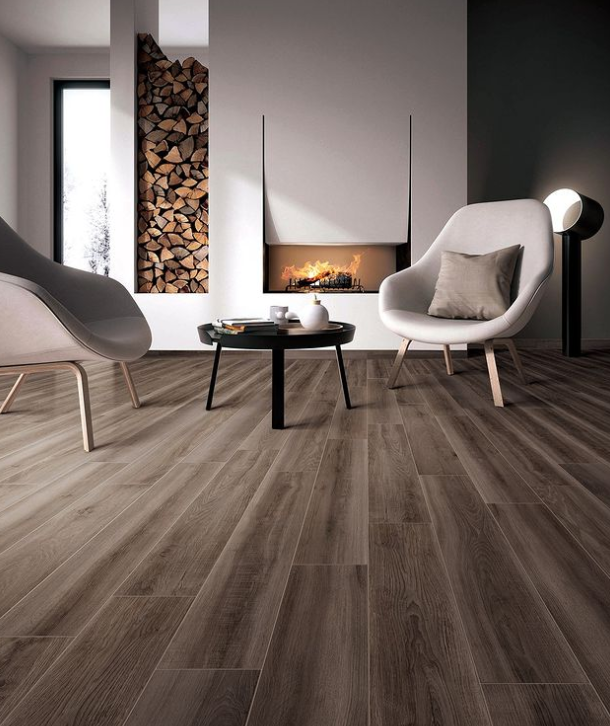 Modern living room with wood flooring, white chairs, a small black table, and a fireplace. Modern living room with wood flooring, white chairs, a small black table, and a fireplace.