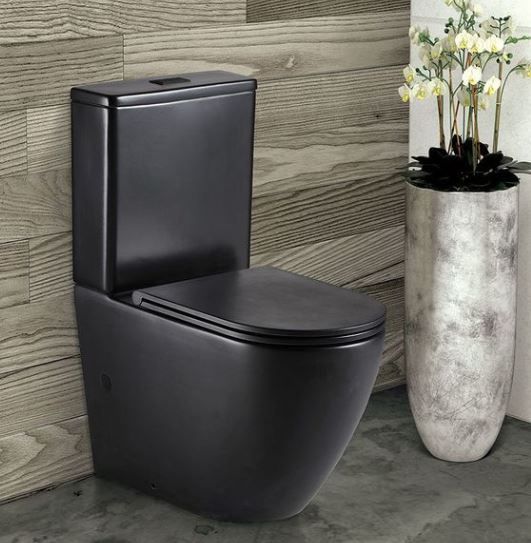 Modern matte black toilet in a tiled bathroom with a tall white vase of flowers nearby