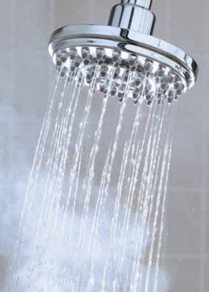 Chrome showerhead spraying water against a gray background Chrome showerhead spraying water against a gray background