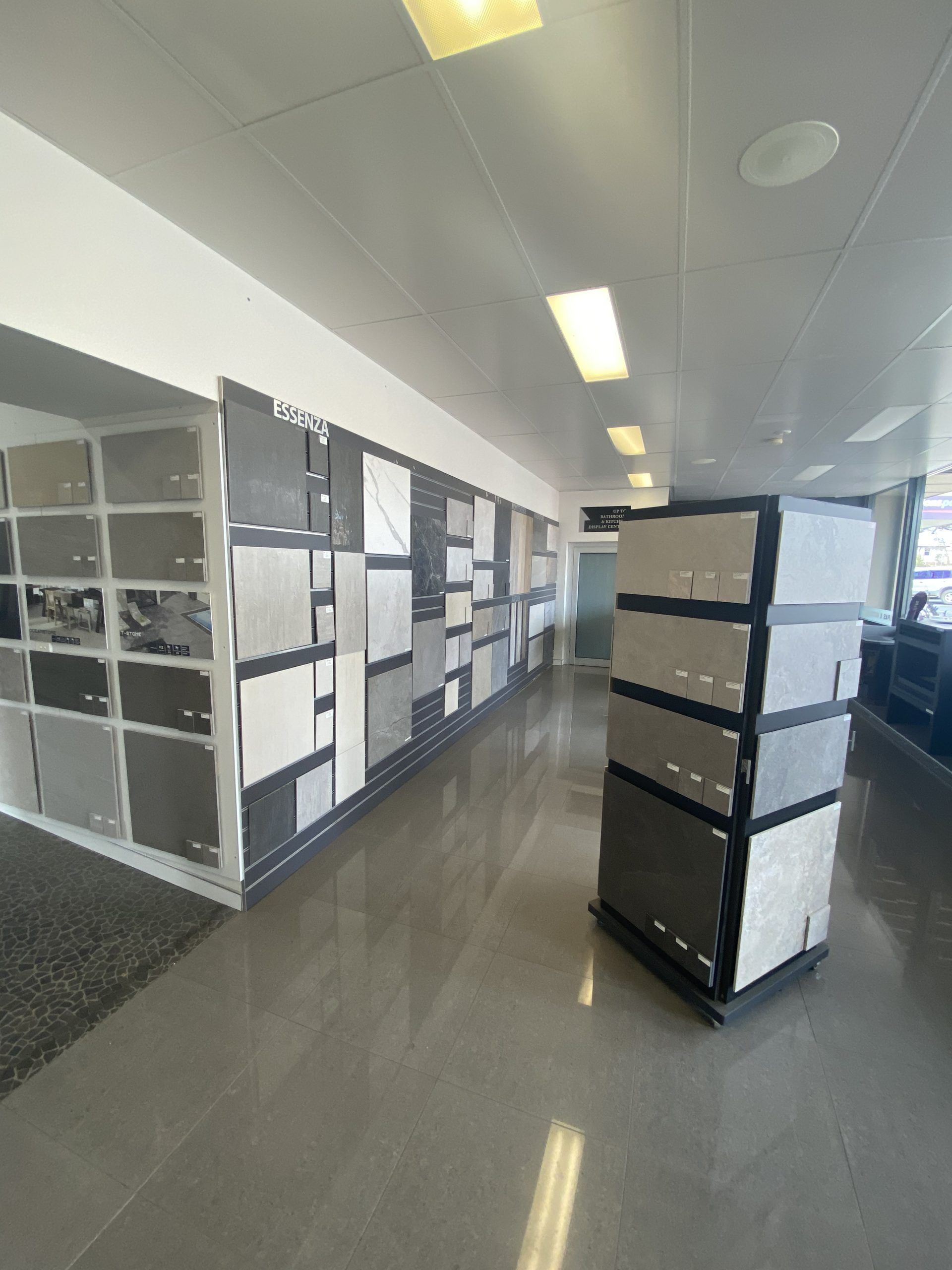 Office hallway with cubicle partitions and filing shelves under bright ceiling lights Office hallway with cubicle partitions and filing shelves under bright ceiling lights