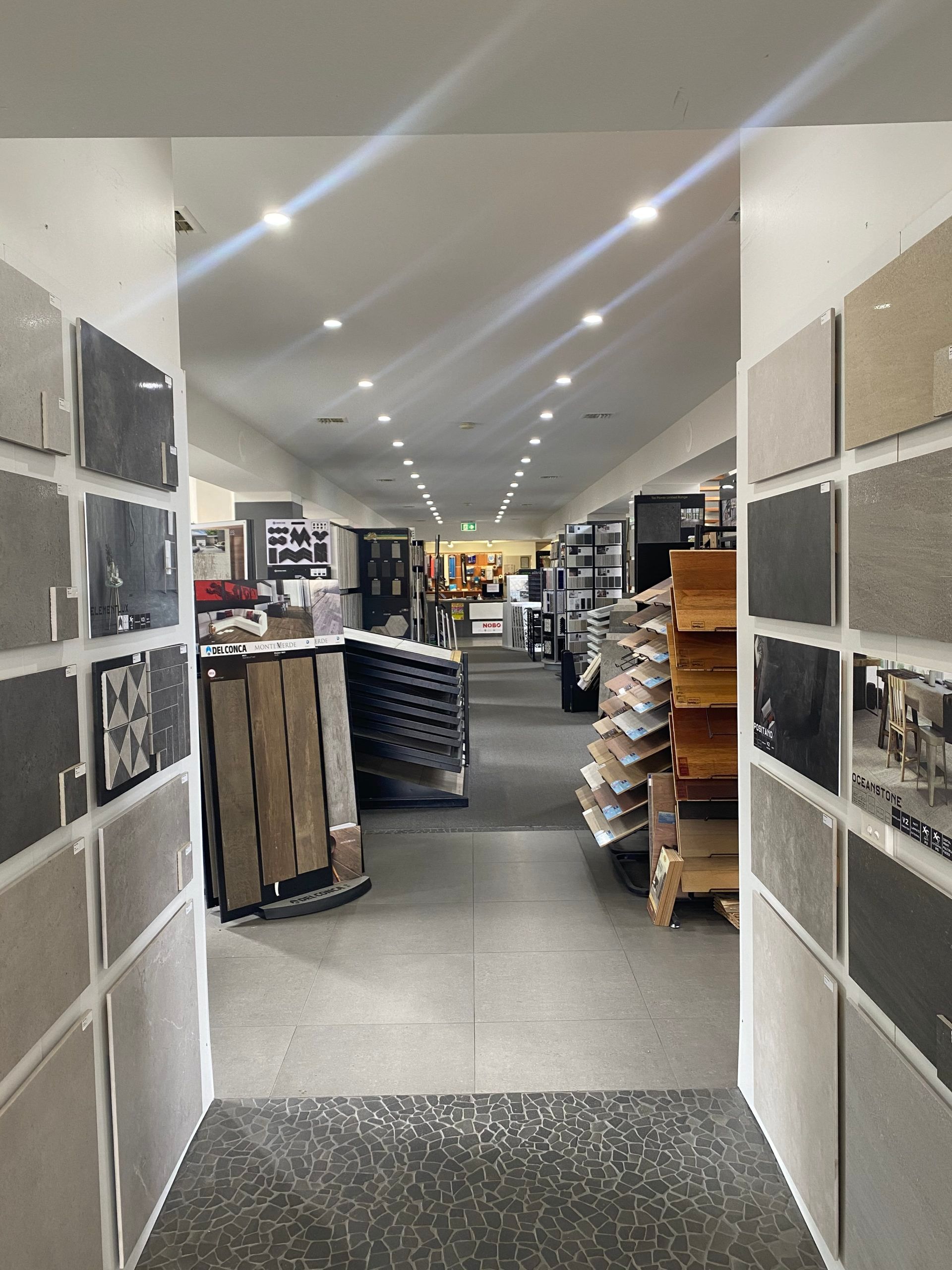 Store aisle with shelves and stacked products under bright ceiling lights