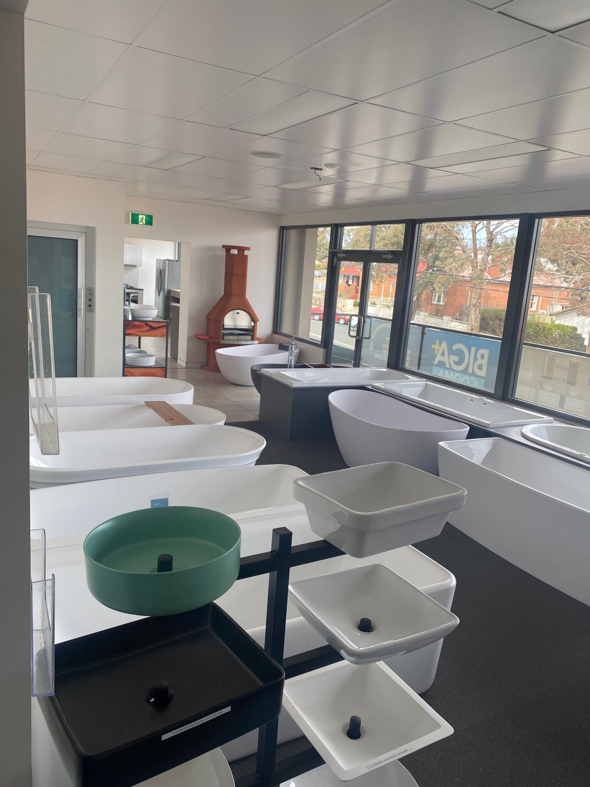 Bathroom showroom with sinks, tubs, and toilets displayed in a bright room.
