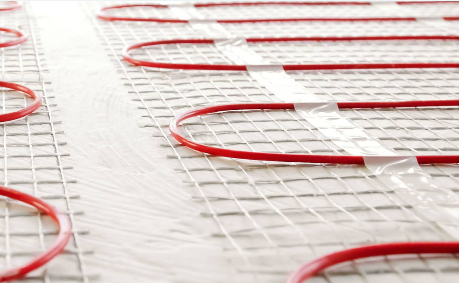 Red coiled hoses arranged in rows on a white industrial floor surface