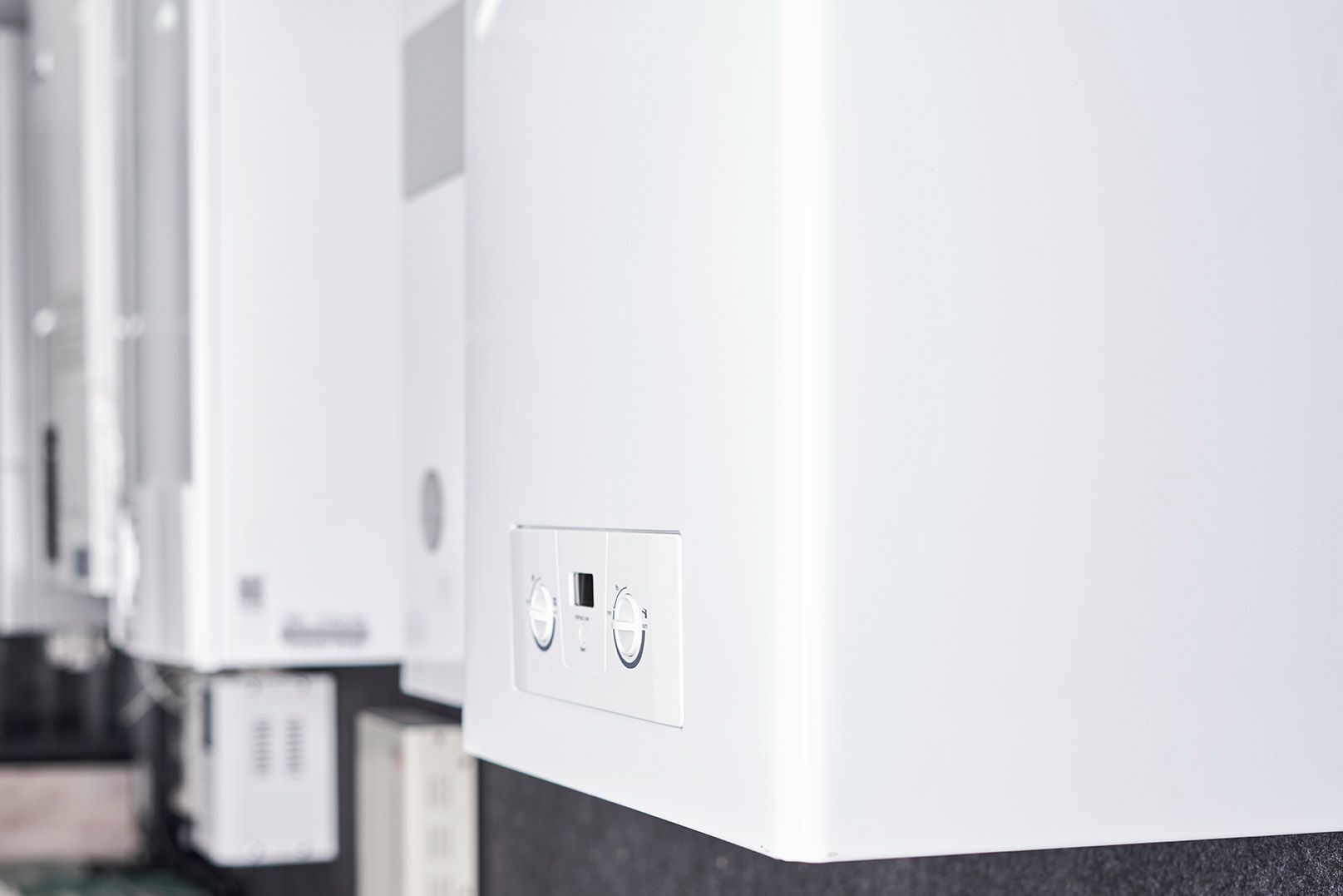 Row of white wall-mounted electrical outlets in a bright hallway Row of white wall-mounted electrical outlets in a bright hallway