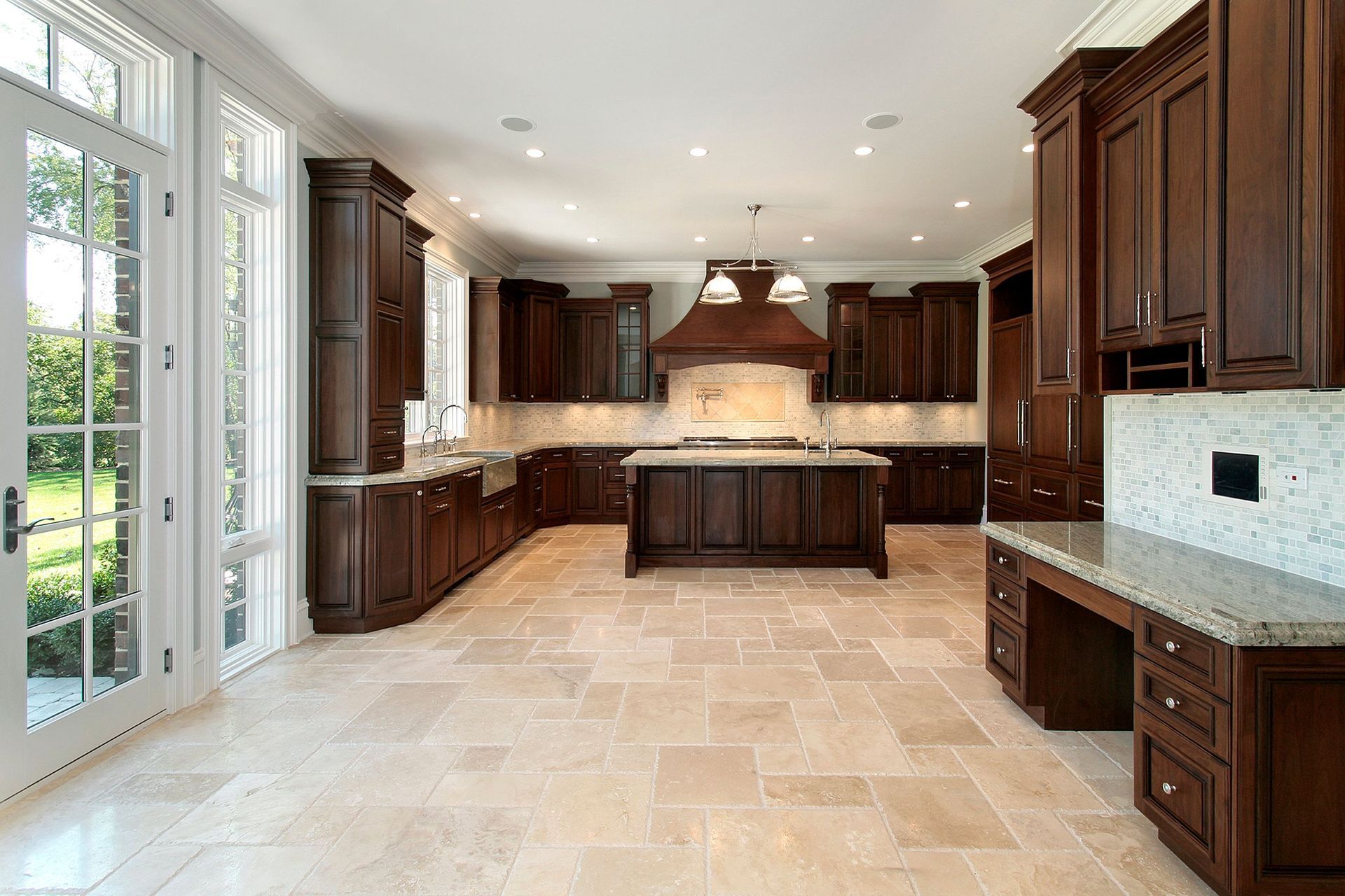 Spacious modern kitchen with dark wood cabinets, beige tile floor, central island, and large windows. Spacious modern kitchen with dark wood cabinets, beige tile floor, central island, and large windows.