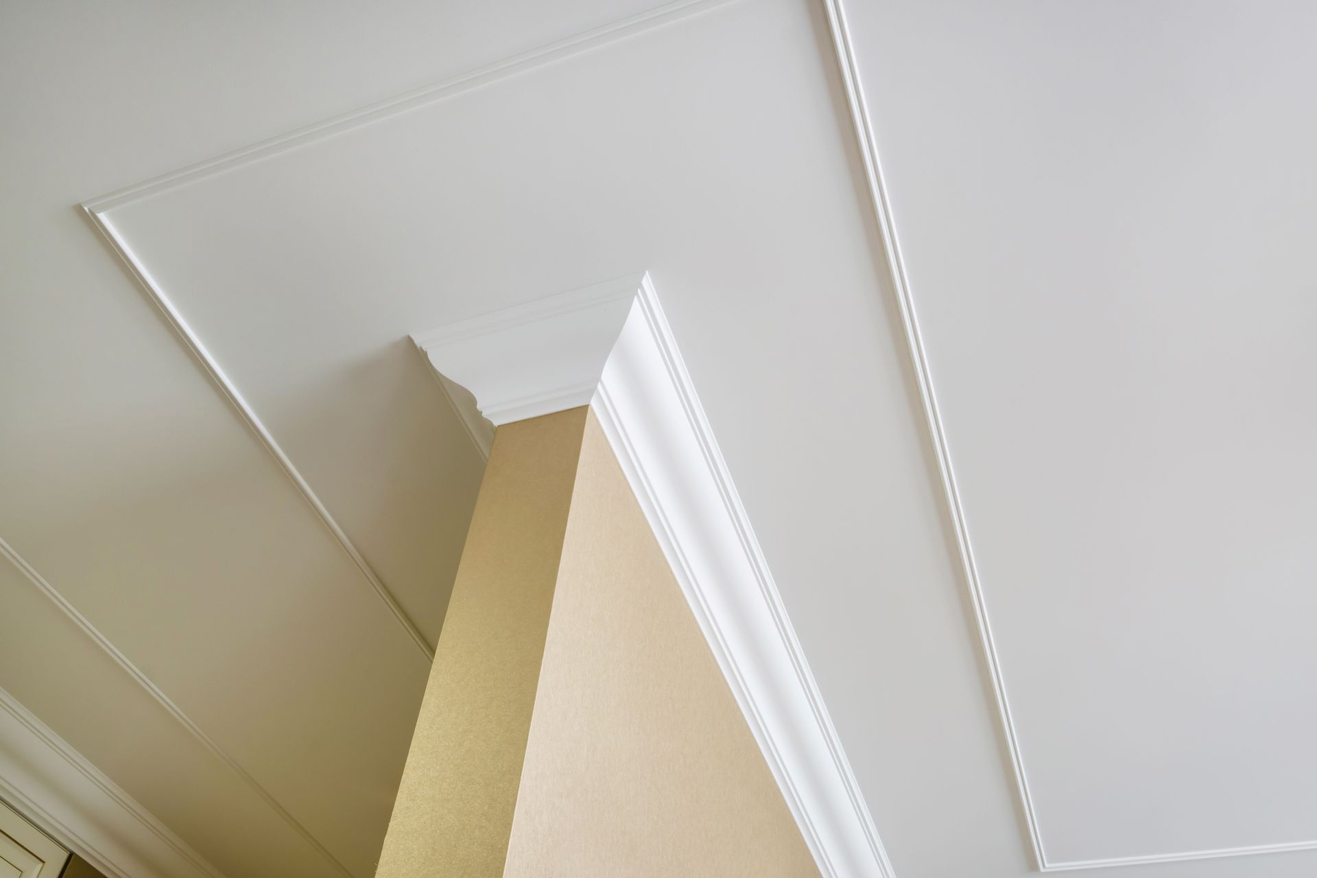 Ceiling corner with white crown molding and beige wall/ceiling intersection Ceiling corner with white crown molding and beige wall/ceiling intersection