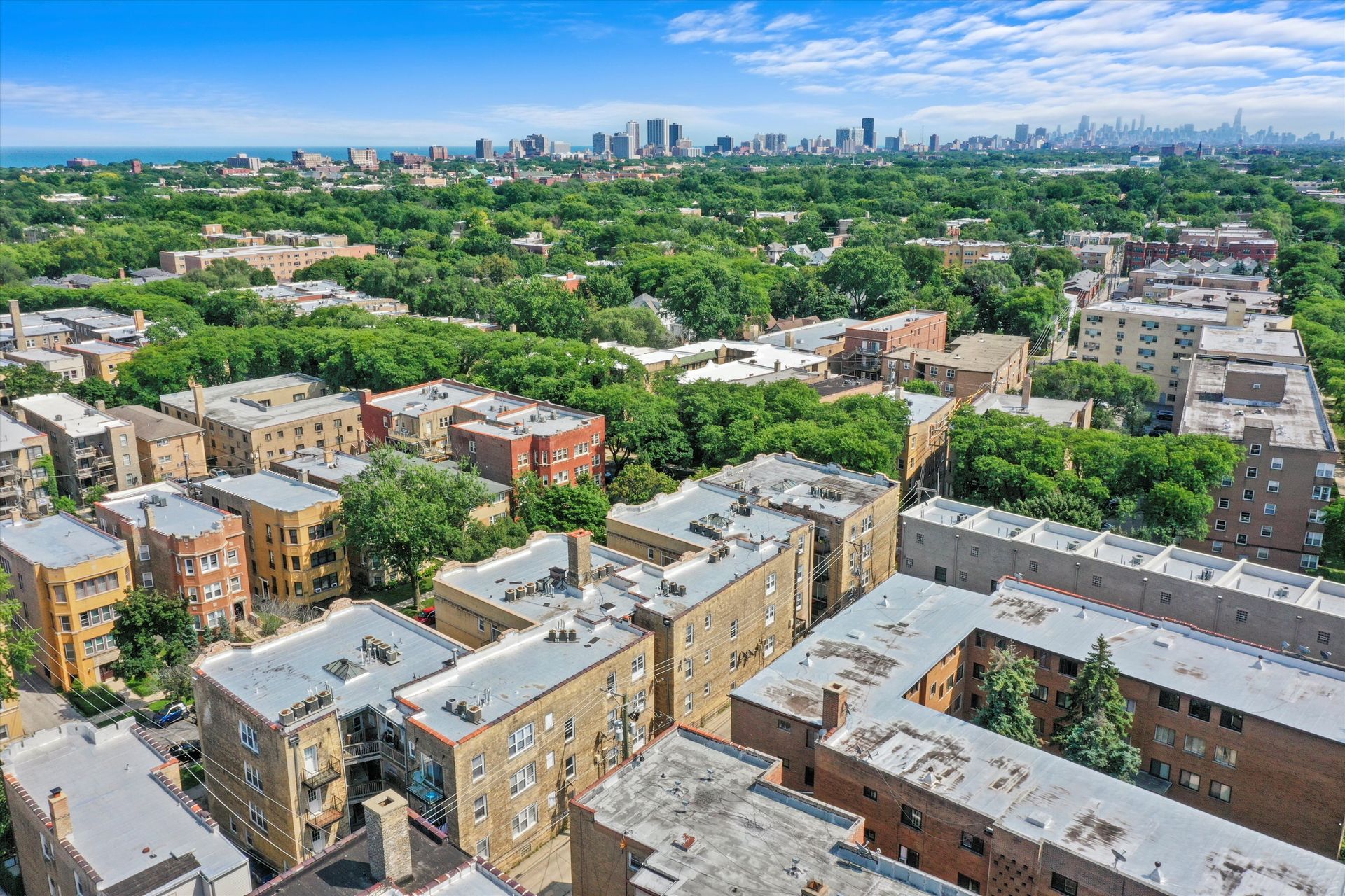 Aerial view of Chicago neighborhood with apartment buildings and cityscape in the background.