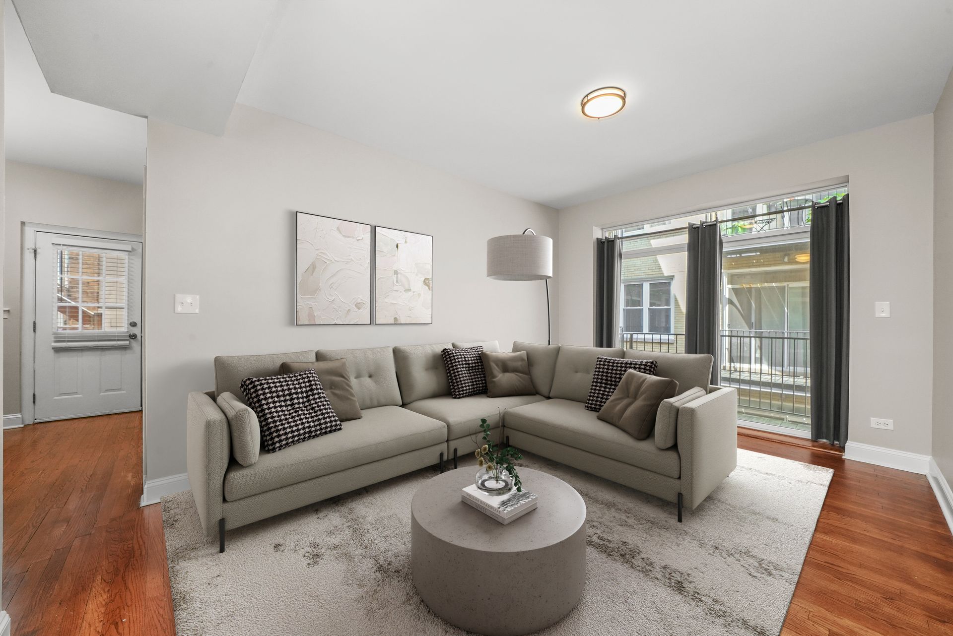 Living room with gray sectional sofa, rug, coffee table, and window to an outdoor area.