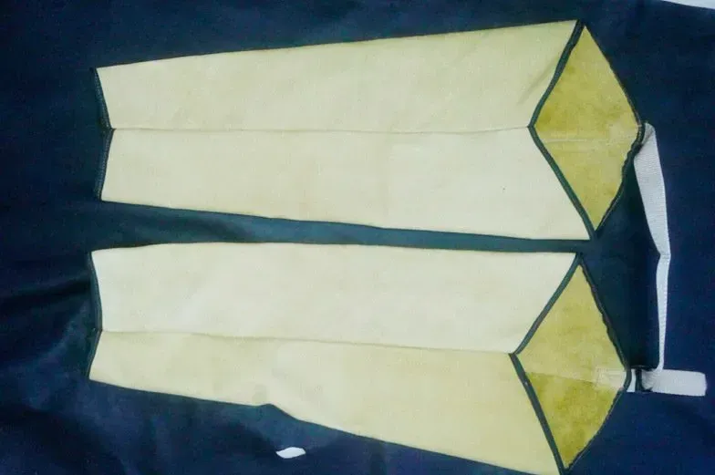 Dos bolsas de tela de color marrón claro, alargadas y con forma de prisma, con ribete oscuro, dispuestas horizontalmente sobre un fondo azul oscuro.