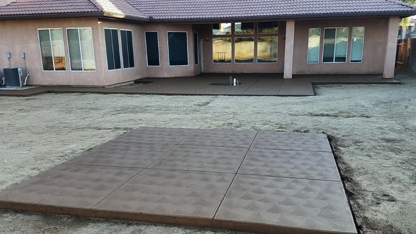 Raised wooden platform in a gravel yard in front of a single-story building.
