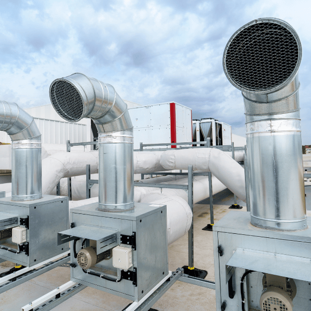 HVAC rooftop units with silver pipes and vents, cloudy sky background.