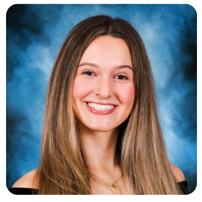 Young person with glasses smiles, wearing off-the-shoulder black top, against a blue-gray background.