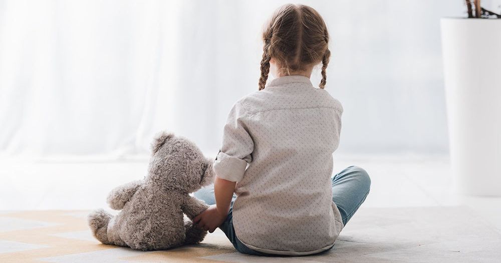 little girl sitting with her teddy bear