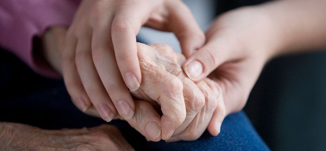 younger person holding the hand of an older person